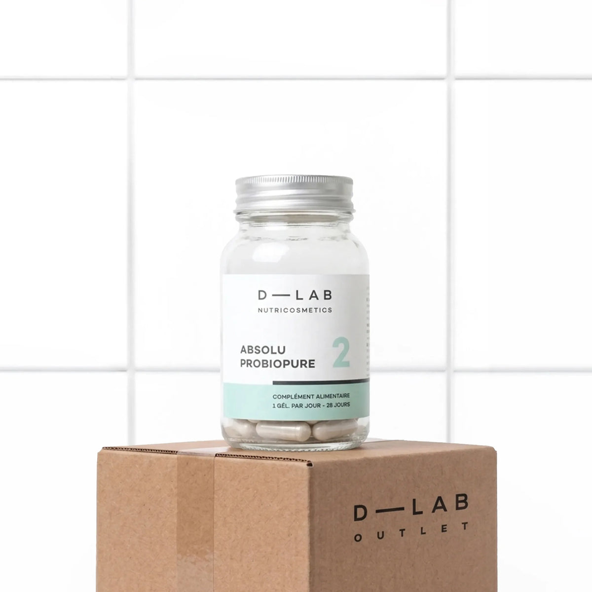 Flacon en verre Absolu Probiopure D-LAB Nutricosmetics, cure 1 mois de 5 souches de probiotiques gastro-résistants, posé sur un carton D-LAB Outlet