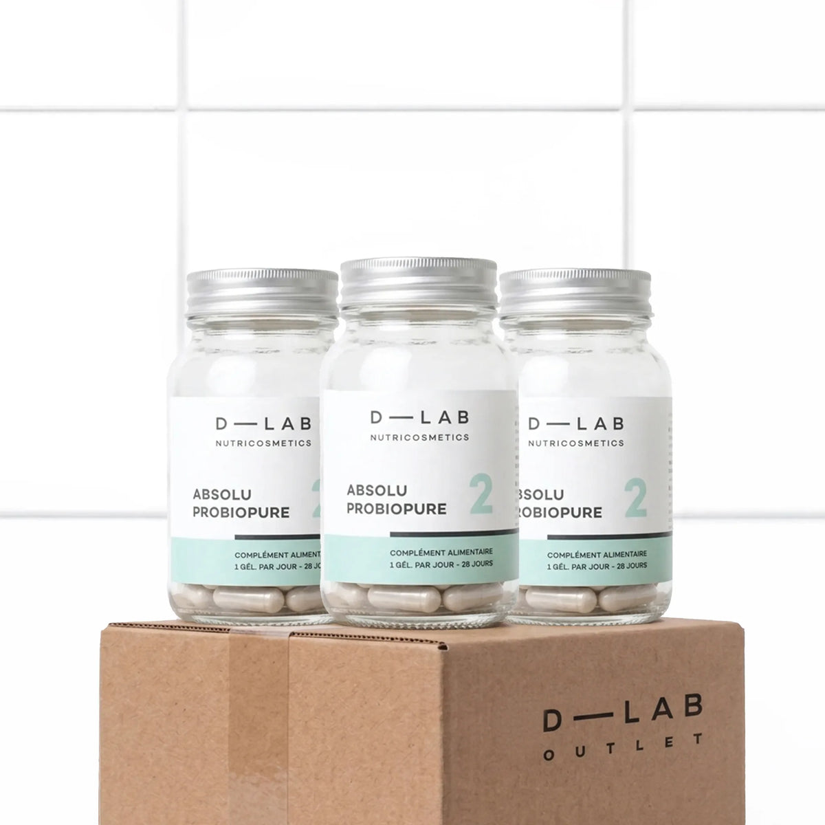 Trois flacons Absolu Probiopure D-LAB alignés, cure 3 mois de probiotiques pour la flore intestinale, packshot sur carton D-LAB Outlet