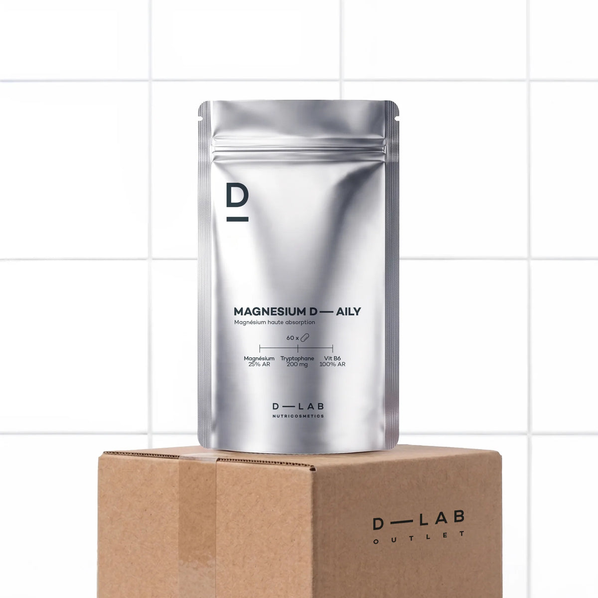 Magnésium Daily D-LAB, doypack, cure d'un mois, sur le carton D-LAB Outlet, devant un mur carrelé blanc